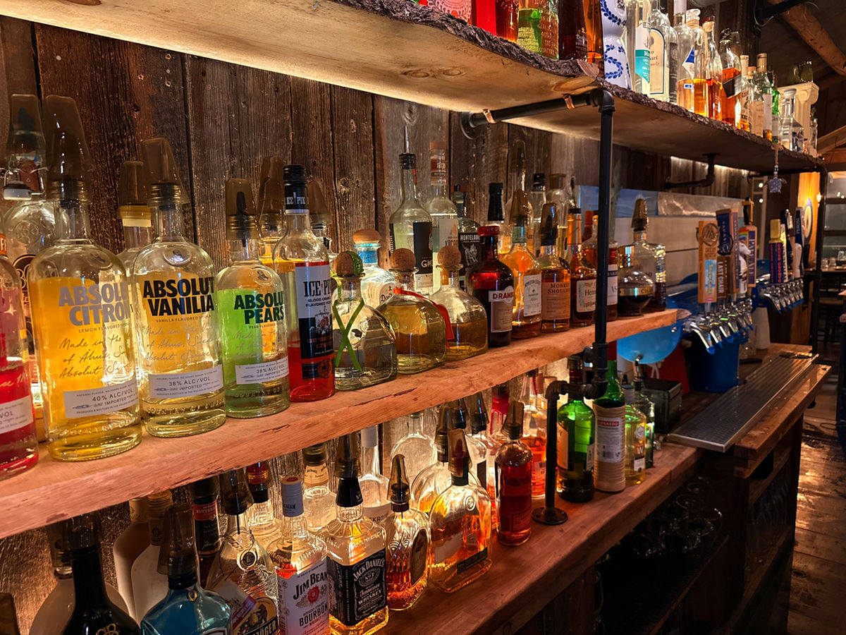 Back-lit shelves of spirits behind the Yamas bar
